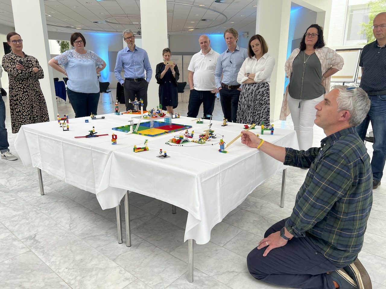 Leaders gather round a workshop's Meta-Model© to hear its story
